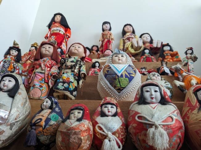 Rows of Japanese dolls on tiered shelves at the All Things Japanese Sale